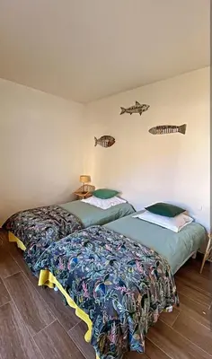 two beds in a room with fish on the wall at Appartement Vue mer en plein centre de Cargese in Cargèse
