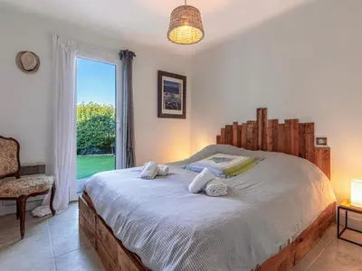 a bedroom with a large bed with a window at Holiday Home Villa Vaccaja by Interhome in Porto-Vecchio