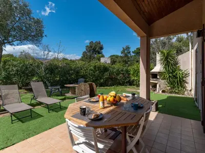 a wooden table with fruit on it on a patio at Holiday Home Villa Vaccaja by Interhome in Porto-Vecchio