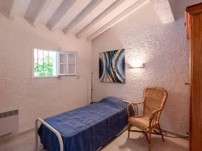 a bedroom with a bed and a chair and a window at Holiday Home Villa Irène by Interhome in Linguizzetta