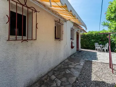 a white house with windows and a patio at Holiday Home Villa Irène by Interhome in Linguizzetta