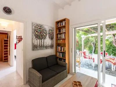 a living room with a couch and a book shelf at Holiday Home Villa Irène by Interhome in Linguizzetta