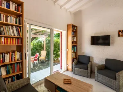 a living room with two chairs and a book shelf at Holiday Home Villa Irène by Interhome in Linguizzetta
