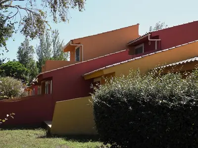 a red and yellow house with bushes in front of it at Holiday Home Studio cabine Type B by Interhome in Borgo
