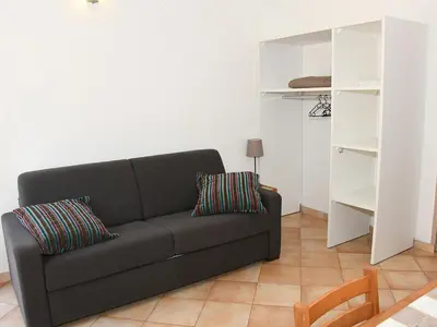 a living room with a black couch and white shelves at Holiday Home Studio cabine Type B by Interhome in Borgo