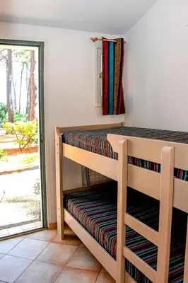 a bedroom with two bunk beds and a sliding glass door at Holiday Home T2 Cabine Type C by Interhome in Borgo