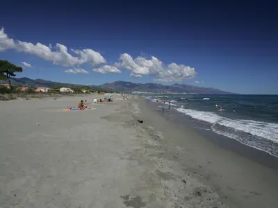 a group of people on a beach near the ocean at Holiday Home T2 Cabine Type C by Interhome in Borgo
