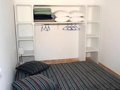 a closet with white shelves and a rug at Holiday Home T2 Cabine Type C by Interhome in Borgo