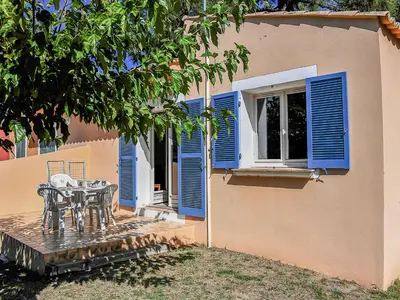 a patio with a table and blue shutters on a house at Holiday Home T3 Cabine by Interhome in Borgo