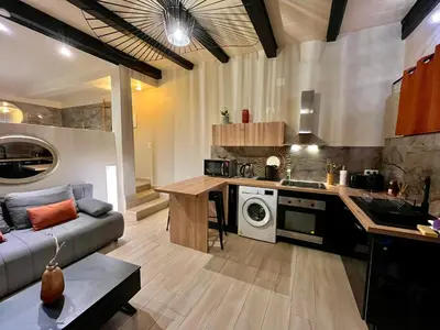 a kitchen and living room with a couch and a table at Beau F2 centre ville in Ajaccio