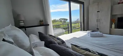 a bedroom with a large bed and a large window at Grand & beau studio climatisé vue sur mer in Propriano