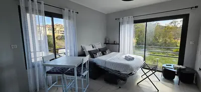 a bedroom with a bed and a large window at Grand & beau studio climatisé vue sur mer in Propriano