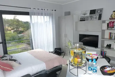 a bedroom with a bed and a window and a table at Grand & beau studio climatisé vue sur mer in Propriano