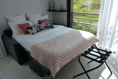 a bedroom with a bed with pillows and a window at Grand & beau studio climatisé vue sur mer in Propriano