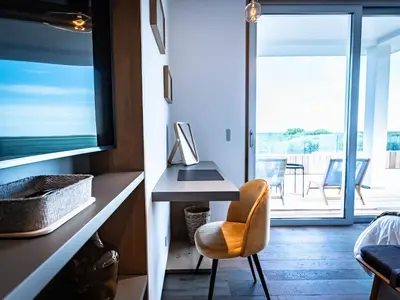 a room with a desk and a chair and a balcony at Porto-Vecchio Palombaggia Villa Azaïtù in Porto-Vecchio