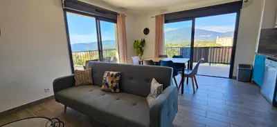 a kitchen and dining room with a table and chairs at T3 Le Myrte vue Mer & Montagne idéalement situé in Propriano