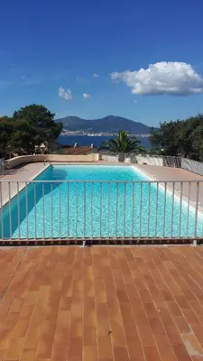 a large swimming pool with the ocean in the background at Appartement cosy à Grosseto-Prugna - Vue sur la mer, 42 m² in Grosseto-Prugna