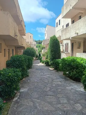 a cobblestone street between two buildings with bushes at Appartement cosy à Grosseto-Prugna - Vue sur la mer, 42 m² in Grosseto-Prugna
