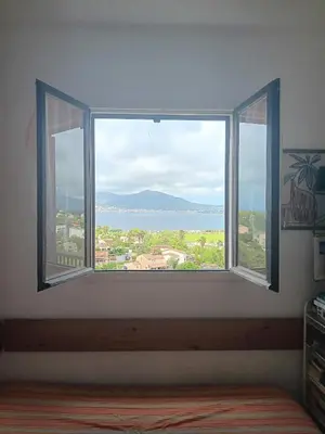 a window in a room with a view of a city at Appartement cosy à Grosseto-Prugna - Vue sur la mer, 42 m² in Grosseto-Prugna