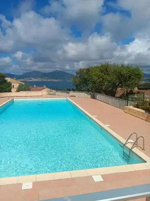 a large swimming pool with blue water at Appartement cosy à Grosseto-Prugna - Vue sur la mer, 42 m² in Grosseto-Prugna