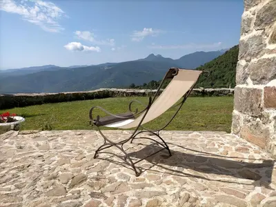 a chair sitting on a patio with mountains in the background at A Vignarella in Ventiseri