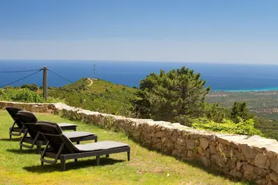 a group of chairs sitting on top of a rock wall at A Vignarella in Ventiseri