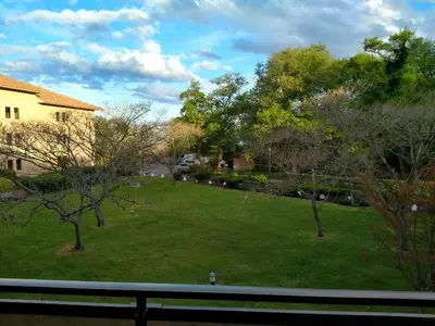a green yard with trees and a house at MORIANI STUDIO CABINE CLIMATISE 4 à 5 pers in San-Nicolao