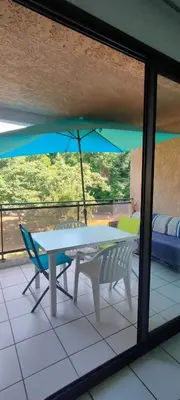 a bedroom with a bed and a kitchen with a refrigerator at MORIANI STUDIO CABINE CLIMATISE 4 à 5 pers in San-Nicolao