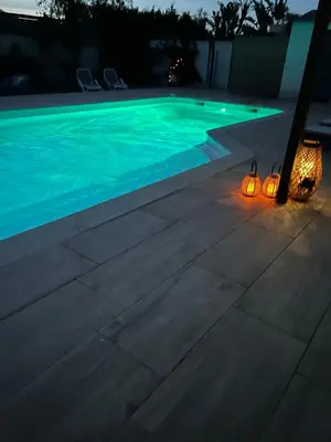 a swimming pool at night with lights next to it at Très belle villa avec piscine chauffée CASALEONI in Prunelli-di-Fiumorbo