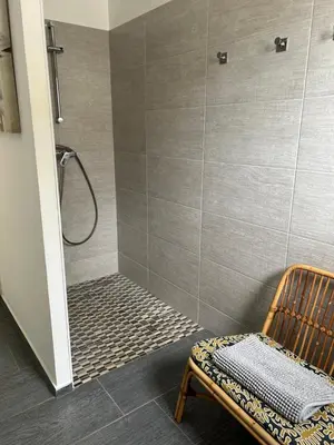 a shower with a bench and a chair in a bathroom at Très belle villa avec piscine chauffée CASALEONI in Prunelli-di-Fiumorbo