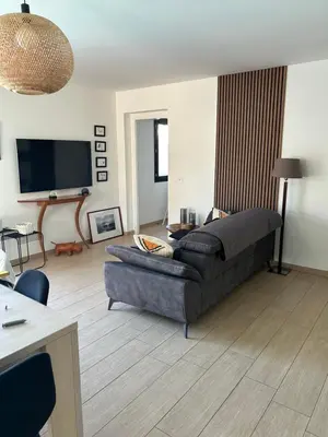 a living room with a couch and a flat screen tv at Très belle villa avec piscine chauffée CASALEONI in Prunelli-di-Fiumorbo