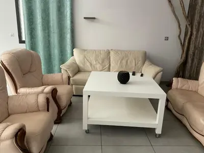a living room with a couch and a table and two chairs at VILLA OCEANE in San-Nicolao