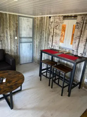 a living room with a table and two stools at L ASCOSU in Ventiseri