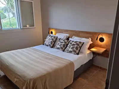 a bedroom with a large bed with two pillows at L'ortu di Quaprice in Figari