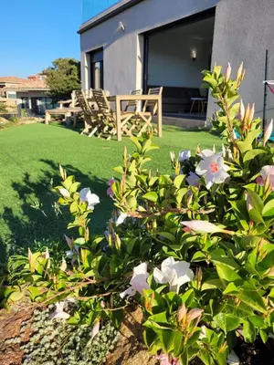 a garden with flowers in front of a house at Appartement neuf 3 chambres vue mer Propriano in Propriano