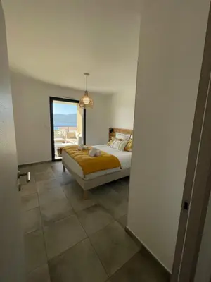 a bedroom with a bed and a large window at Superbe T3 NEUF VUE MER in Propriano