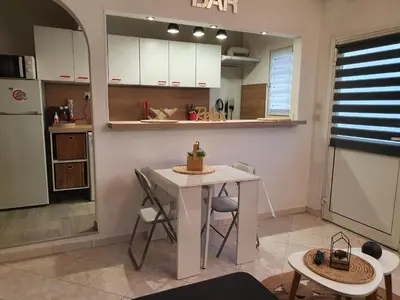 a kitchen with a small white table and a counter at Villa les palmiers -Stretta di i mandarini in Lucciana