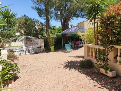a patio with a fence and a table and chairs at Villa les palmiers -Stretta di i mandarini in Lucciana