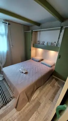 a bedroom with a large bed in a room at Le petit chalet de Charlène in San-Gavino-di-Carbini