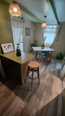 a living room with a table and a chair at Le petit chalet de Charlène in San-Gavino-di-Carbini