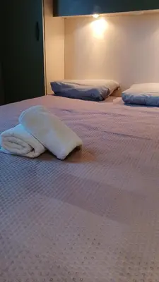 two white towels are laying on a bed at Le petit chalet de Charlène in San-Gavino-di-Carbini