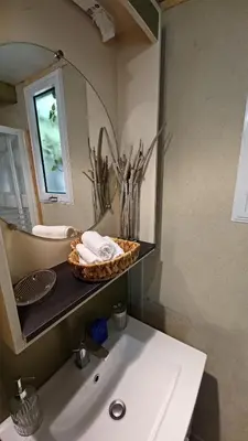 a bathroom with a sink and a mirror at Le petit chalet de Charlène in San-Gavino-di-Carbini