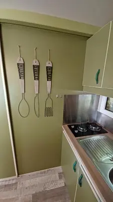 a kitchen with utensils hanging on a wall at Le petit chalet de Charlène in San-Gavino-di-Carbini