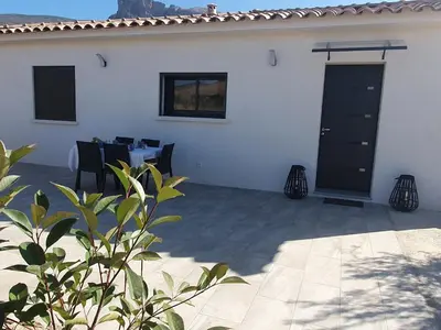 a patio with a table and a black door at Villa l'alivu in Afa