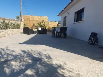 a patio with a table and chairs next to a building at Villa l'alivu in Afa