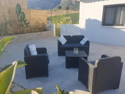 a patio with couches and chairs and a table at Villa l'alivu in Afa