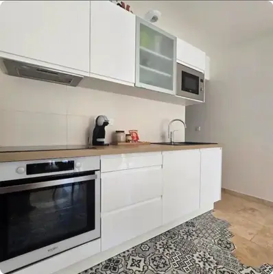 a kitchen with white cabinets and a sink at Domaine U Filanciu - Centru di Corsica in Moltifao