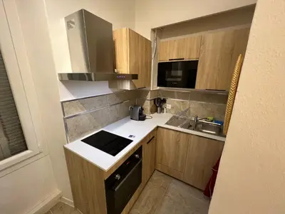 a small kitchen with a sink and a stove at Ajaccio T2 Standing Place du marché in Ajaccio