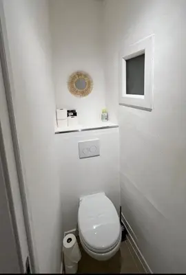 a white bathroom with a toilet and a mirror at Ajaccio T2 Standing Place du marché in Ajaccio