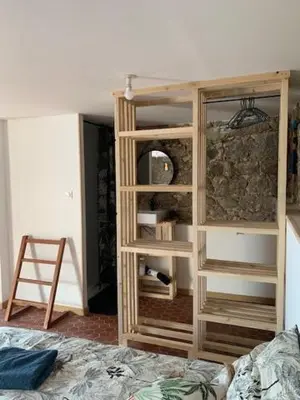 a bedroom with a wooden book shelf and a bed at Chez LULU appartement de caractère in Cozzano